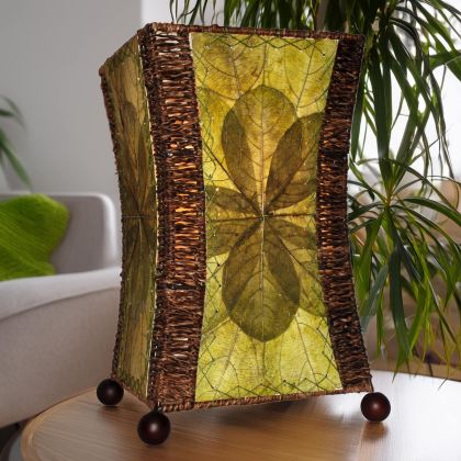 Hourglass?shaped table lamp crafted by Eangee Home Design sculpted from green fossilized jackfruit leaves, abaca accents; graceful curve glows as radiant light glows through every vein; sustainably handcrafted by skilled artisans