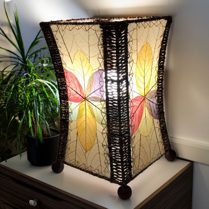 In a minimalist loft with natural textures, crafted by the artisans of Eangee Home Design, the Hourglass Table Lamp in multi color stands gracefully, featuring jackfruit leaf panels, abaca rope accents, wrought iron frame, eco friendly, adding warmth and character to the space.