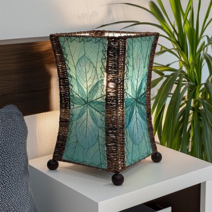 Hourglass?shaped table lamp crafted by Eangee Home Design sculpted from sea blue fossilized jackfruit leaves, abaca accents; graceful curve glows as cozy light filters through the natural leaf veins; artisan?made with renewable materials