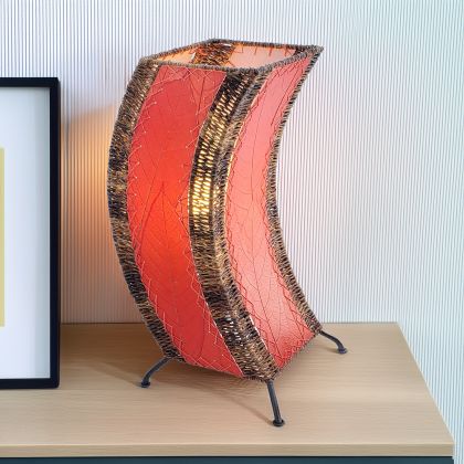 In a modern interior with earth tones, crafted by the artisans of Eangee Home Design, the C Shape Table Lamp in red stands gracefully, featuring fossilized cocoa leaf shade, abaca rope accents, fair trade, handcrafted, adding warmth and character to the space.