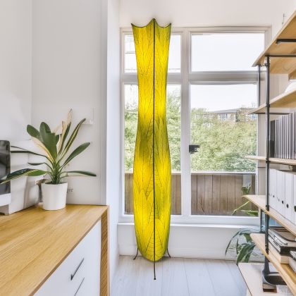 Crafted by the artisans of Eangee Home Design, the Flowerbud Giant Floor Lamp in green against a clean backdrop, featuring fossilized cocoa leaf shade.