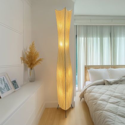 In a reading nook with a linen armchair, the Flowerbud Giant Floor crafted by the artisans of Eangee Home Design Lamp in natural finish by Eangee Home Design stands tall, its fossilized cocoa leaf panels and hand placed natural leaves casting a warm glow that the flower bud giant floor lamp draws you in before it even lights up.