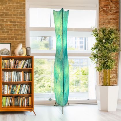In a reading nook with a linen armchair, the Flowerbud Giant Floor crafted by the artisans of Eangee Home Design Lamp in sea blue finish by Eangee Home Design stands tall, its fossilized cocoa leaf panels and hand placed natural leaves casting a warm glow that the flower bud giant floor lamp draws you in before it even lights up.