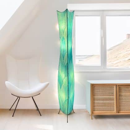 In a softly lit reading nook, crafted by the artisans of Eangee Home Design, the Flowerbud Giant Floor Lamp in sea blue stands gracefully, featuring fossilized cocoa leaf shade, adding warmth and character to the space.