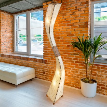 Crafted by the artisans of Eangee Home Design, the Flow Giant Floor Lamp in natural against a clean backdrop, featuring fossilized cocoa leaf shade, abaca rope accents, eco friendly.