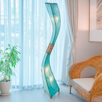 In a entryway beside a console table, the Flow Giant Floor crafted by the artisans of Eangee Home Design Lamp in sea blue finish by Eangee Home Design stands beside a ceramic vase, its fossilized cocoa leaf panels, abaca twine accents, and hand placed natural leaves casting a warm glow that there's a moment just before the wind shifts or a dancer turns where motion becomes emotion.