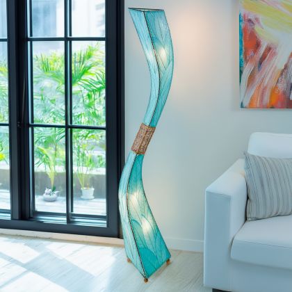 Crafted by the artisans of Eangee Home Design, the Flow Giant Floor Lamp in sea blue against a clean backdrop, featuring fossilized cocoa leaf shade, abaca rope accents, eco friendly.