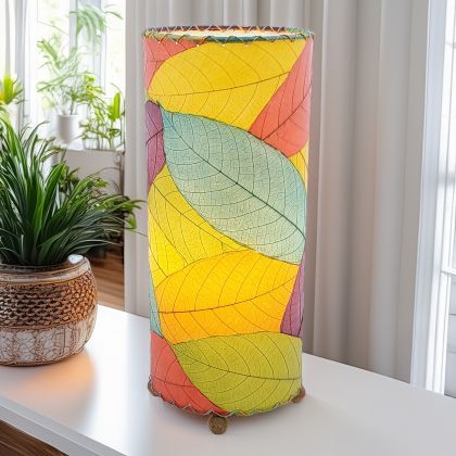 In a modern interior with earth tones, crafted by the artisans of Eangee Home Design, the Cocoa Leaf Cylinder Table Lamp in multi color stands gracefully, featuring fossilized cocoa leaf shade, wrought iron frame, handcrafted, adding warmth and character to the space.