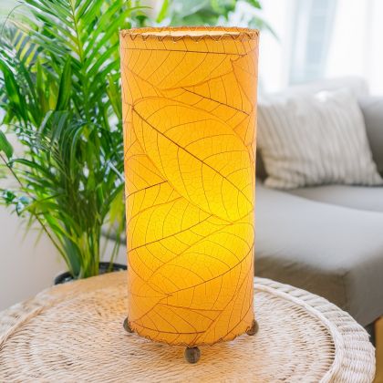 Slim cylinder table lamp crafted by Eangee Home Design in orange fossilized cocoa leaves, each panel hand?laminated and stitched; minimalist form offers textural leaf detail while ambient light spills through every vein; eco?friendly, artisan?crafted design