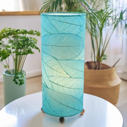 Slim cylinder table lamp crafted by Eangee Home Design in sea blue fossilized cocoa leaves, each panel hand?laminated and stitched; minimalist form offers textural leaf detail while soothing light spills through the natural leaf veins; handcrafted sustainably by fair?trade artisans