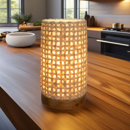 In a sun drenched entryway, crafted by the artisans of Eangee Home Design, the Mini Paper Cylinder Table Lamp Mesh in natural stands gracefully, featuring reclaimed mango wood base, recycled paper shade, sustainably sourced, recycled materials, adding warmth and character to the space.