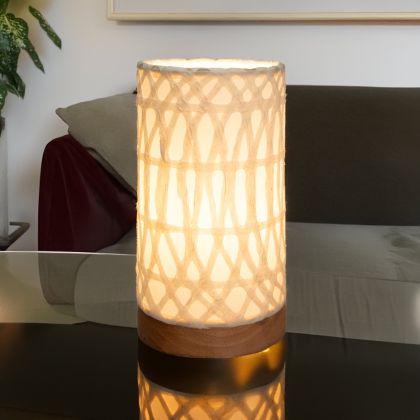 In a coastal inspired living room, crafted by the artisans of Eangee Home Design, the Mini Paper Cylinder Table Lamp Arches in natural stands gracefully, featuring reclaimed mango wood base, recycled paper shade, sustainably sourced, recycled materials, adding warmth and character to the space.