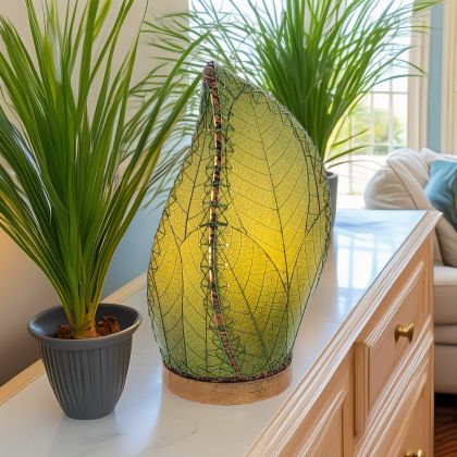 Crafted by the artisans of Eangee Home Design, the Leaflet Table Lamp in green against a clean backdrop, featuring fossilized cocoa leaf shade, abaca rope accents, reclaimed mango wood base, wrought iron frame, sustainably sourced.