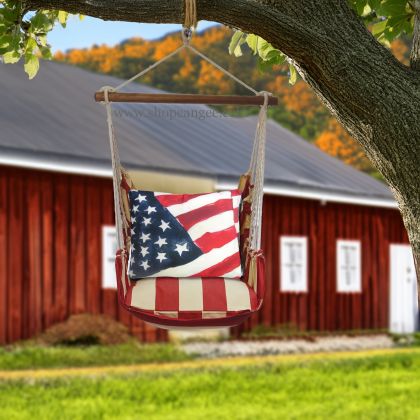 Multi colored outdoor swing crafted by the artisans of Magnolia Casual called the Swing Set 4 piece Americana Stripe w/ Flag featuring 100 percent weather resistant fabric, weather resistant polyester fabric, handcrafted shown against a clean backdrop featuring with a stripe motif.
