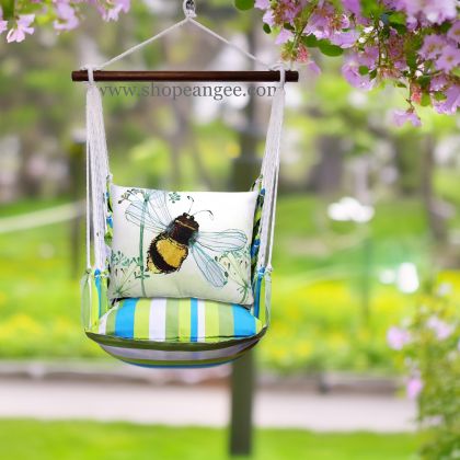 In a cozy garden seating area a multi colored outdoor swing crafted by the artisans of Magnolia Casual called the Swing Set 4 piece Beach Boulevard Stripe w/ Bumblebee Bee Wisp is displayed featuring 100 percent weather resistant fabric, weather resistant polyester fabric adding comfort and style to the space featuring with a stripe motif.