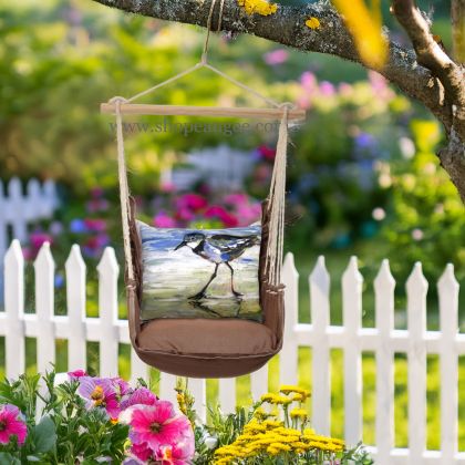 In a shaded porch swing a multi colored outdoor swing crafted by the artisans of Magnolia Casual called the Swing Set 4 piece Chocolate Solid w/ Sandpiper is displayed featuring 100 percent weather resistant fabric, weather resistant polyester fabric, artisan, natural materials adding comfort and style to the space.