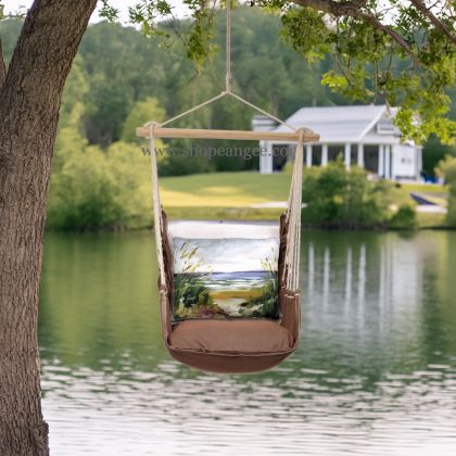 In an outdoor reading nook a multi colored outdoor swing crafted by the artisans of Magnolia Casual called the Swing Set 4 piece Chocolate Solid w/ Beach Path is displayed featuring 100 percent weather resistant fabric, weather resistant polyester fabric, artisan, natural materials adding comfort and style to the space.
