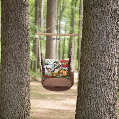 In an outdoor reading nook a multi colored outdoor swing crafted by the artisans of Magnolia Casual called the Swing Set 4 piece Chocolate Solid w/ Watering Can & Flower Pots is displayed featuring 100 percent weather resistant fabric, weather resistant polyester fabric, artisan, natural materials adding comfort and style to the space featuring with a floral motif.