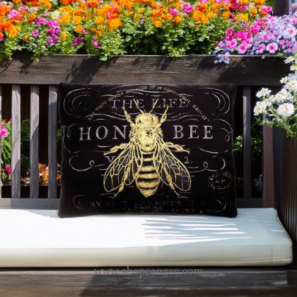 In a poolside chaise a multi colored outdoor pillow crafted by the artisans of Magnolia Casual called the Outdoor Pillow Vintage Bee 19x24 is displayed featuring 100 percent weather resistant fabric, weather resistant polyester fabric adding comfort and style to the space featuring with a bee motif.