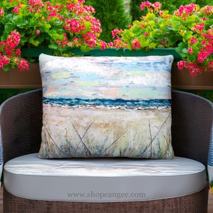 In a cozy garden seating area a multi colored outdoor pillow crafted by the artisans of Magnolia Casual called the Outdoor Pillow Coastal Landscape 2 19x24 is displayed featuring quality outdoor fabric, natural materials adding comfort and style to the space.
