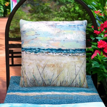 In a poolside chaise a multi colored outdoor pillow crafted by the artisans of Magnolia Casual called the Outdoor Pillow Coastal Landscape 2 18x18 is displayed featuring quality outdoor fabric, natural materials adding comfort and style to the space.