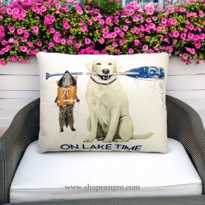 In a shaded porch swing a multi colored outdoor pillow crafted by the artisans of Magnolia Casual called the Outdoor Pillow Lake Time 19x24 is displayed featuring quality outdoor fabric adding comfort and style to the space.