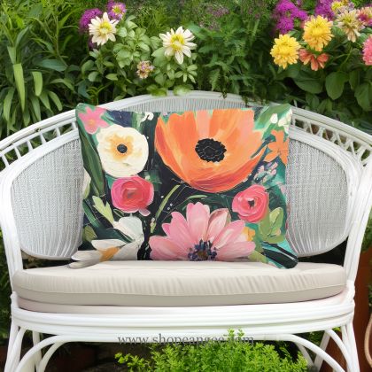In an outdoor reading nook a multi colored outdoor pillow crafted by the artisans of Magnolia Casual called the Outdoor Pillow Spring Fling 19x24 is displayed featuring quality outdoor fabric adding comfort and style to the space.