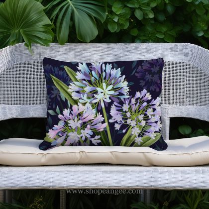 In a cozy garden seating area a multi colored outdoor pillow crafted by the artisans of Magnolia Casual called the Outdoor Pillow Midnight Garden Lilies 19x24 is displayed featuring handwoven textile adding comfort and style to the space.