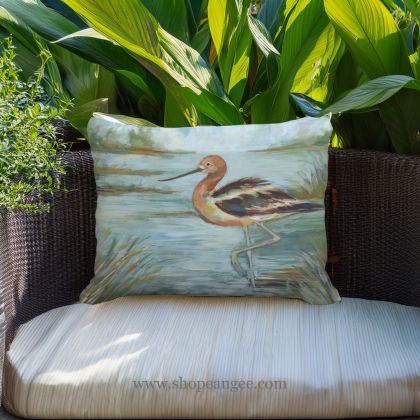 In a coastal inspired deck chair a multi colored outdoor pillow crafted by the artisans of Magnolia Casual called the Outdoor Pillow Avocet Bird in Water 19x24 is displayed featuring quality outdoor fabric, natural materials adding comfort and style to the space featuring with a bird motif.