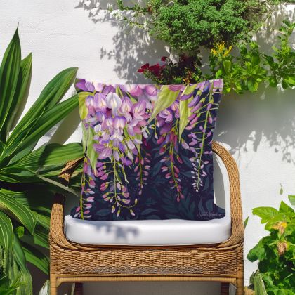 In a poolside chaise a multi colored outdoor pillow crafted by the artisans of Magnolia Casual called the Outdoor Pillow Midnight Garden Wisteria 18x18 is displayed featuring handwoven textile adding comfort and style to the space.