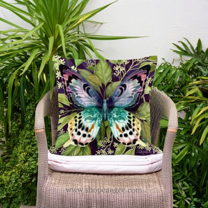 In a cozy garden seating area a multi colored outdoor pillow crafted by the artisans of Magnolia Casual called the Outdoor Pillow Mystic Butterfly 18x18 is displayed featuring quality outdoor fabric adding comfort and style to the space featuring with a butterfly motif.
