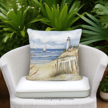 In a sunlit patio lounge a multi colored outdoor pillow crafted by the artisans of Magnolia Casual called the Outdoor Pillow Beach and Lighthouse 18x18 is displayed featuring quality outdoor fabric adding comfort and style to the space.