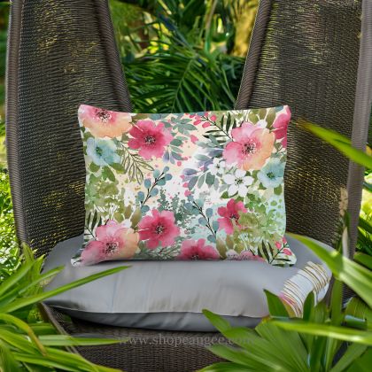 In a coastal inspired deck chair a multi colored outdoor pillow crafted by the artisans of Magnolia Casual called the Outdoor Pillow Meadow Dance 1 13x18 is displayed featuring 100 percent weather resistant fabric adding comfort and style to the space.