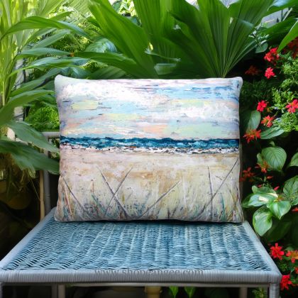 In a poolside chaise a multi colored outdoor pillow crafted by the artisans of Magnolia Casual called the Outdoor Pillow Coastal Landscape 2 13x18 is displayed featuring quality outdoor fabric, natural materials adding comfort and style to the space.