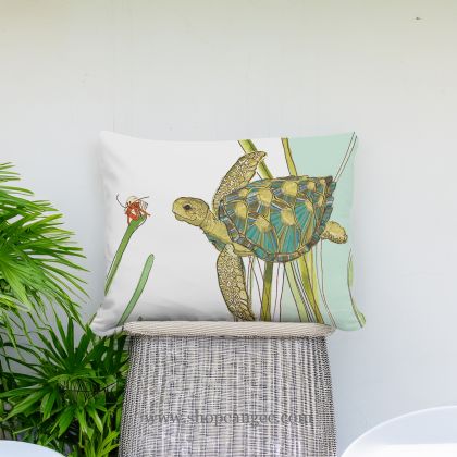 In a poolside chaise a sea outdoor pillow crafted by the artisans of Magnolia Casual called the Outdoor Pillow Sea Turtle 13x18 is displayed featuring quality outdoor fabric adding comfort and style to the space featuring with a sea turtle motif.