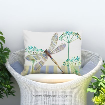 In a poolside chaise a multi colored outdoor pillow crafted by the artisans of Magnolia Casual called the Outdoor Pillow Dragonfly Wisp 13x18 is displayed featuring quality outdoor fabric adding comfort and style to the space featuring with a dragonfly motif.