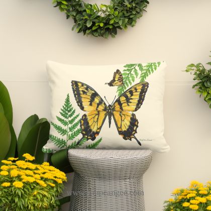 In a shaded porch swing a multi colored outdoor pillow crafted by the artisans of Magnolia Casual called the Outdoor Pillow Beautiful Butterfly 13x18 is displayed featuring quality outdoor fabric adding comfort and style to the space featuring with a butterfly motif.