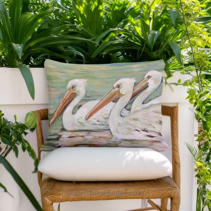 In a coastal inspired deck chair a multi colored outdoor pillow crafted by the artisans of Magnolia Casual called the Outdoor Pillow 3 Pelicans Swimming 13x18 is displayed featuring quality outdoor fabric adding comfort and style to the space.