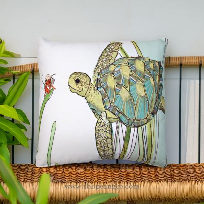 In an outdoor reading nook a sea outdoor pillow crafted by the artisans of Magnolia Casual called the Outdoor Pillow Sea Turtle 18x18 is displayed featuring quality outdoor fabric adding comfort and style to the space featuring with a sea turtle motif.