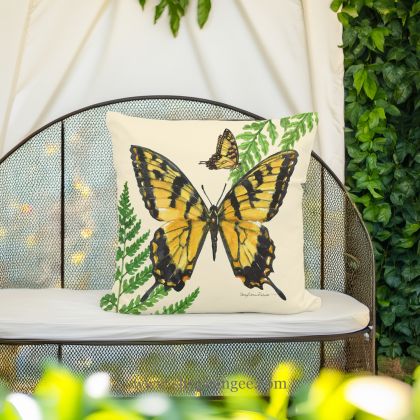 In a sunlit patio lounge a multi colored outdoor pillow crafted by the artisans of Magnolia Casual called the Outdoor Pillow Beautiful Butterfly 18x18 is displayed featuring quality outdoor fabric adding comfort and style to the space featuring with a butterfly motif.