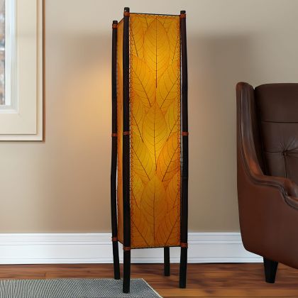 Orange Fortune cocoa leaf floor lamp on bamboo frame, rich amber tower adding warm ambient glow beside leather chair by Eangee Home Design
