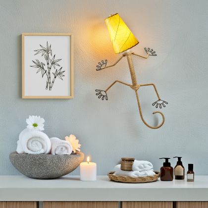 Eangee Home Design Gecko Wall Sconce in yellow with a shade made of real cocoa leaves, cheerful lizard lamp illuminating a serene vanity area