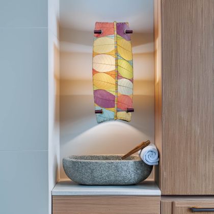 Eangee Home Design Banana Wall Sconce in multicolor with a shade made of real cocoa leaves, casting vibrant light above a stone vessel sink in a modern bathroom niche