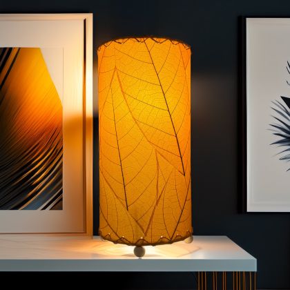 Handcrafted Eangee orange mini cylinder lamp with cocoa leaf shade, brightening a modern console table with framed wall art in the background.