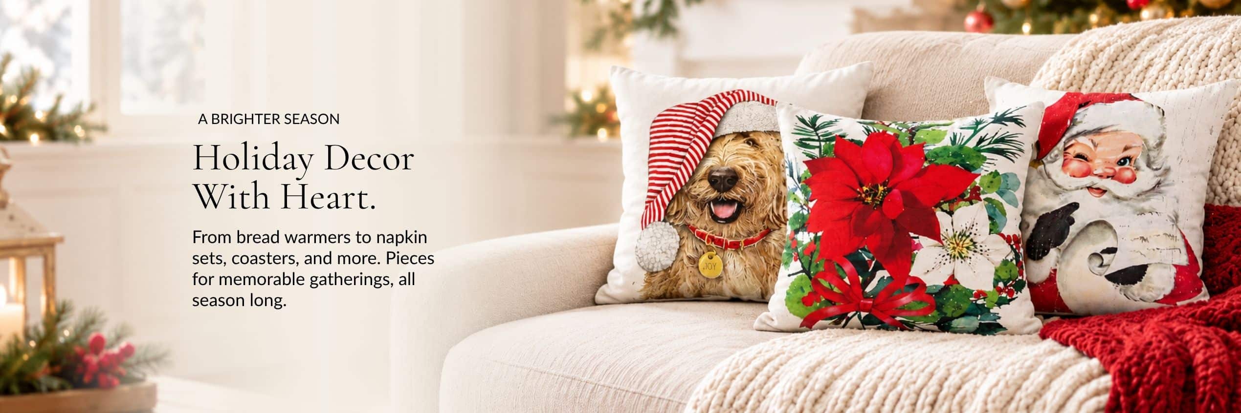 Holiday Décor With Heart. A cozy sofa with holiday pillows featuring a dog in a Santa hat, poinsettias, and Santa with a penguin.